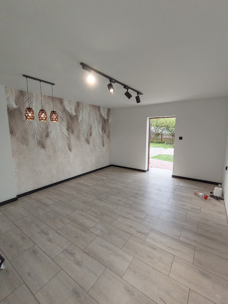 Przestronny jasny salon z ozdobną tapetą